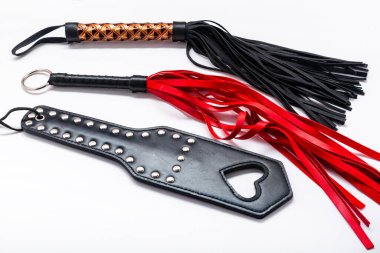 Beyaz arka planda kırbaç. Yetişkinlerin cinsel oyunları için aksesuarlar. BDSM için oyuncaklar, şaplak cihazları. Şaplak ve ceza konsepti. Köle Spank Paddle, bdsm, yetişkin kırbaçları. kopyalama alanı. bdsm için ayarla