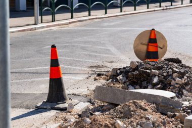 Trafik konisi olan kapalı bir cadde, karayolu inşaatı. Asfalt yüzeyindeki trafik konisi kısmen beyaz yol işaretlerini silmiş. Kapat..