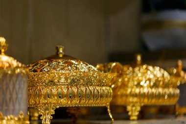 Bir masanın üzerindeki açık şenlikli altın vazo arka plan seçici odak ve sığ alan derinliğidir. Kapat.