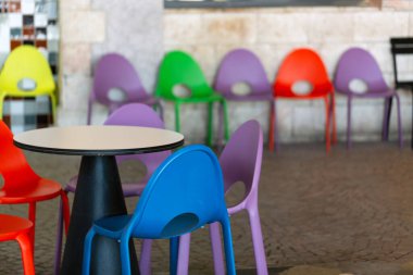 Renkli plastik sandalyeleri ve masaları olan umumi yemek alanının içi