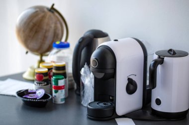 Kahve makinesinin, elektrikli su ısıtıcısının ve küreyi yakın plan görüntüsü.