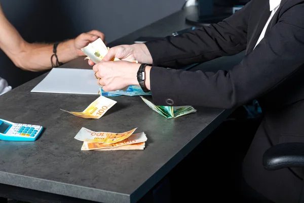 İşveren olarak ofiste çalışan işçilere nakit (ILS shekels para) ödeyen bir işadamı - maaş, kredi ve rüşvet kavramları