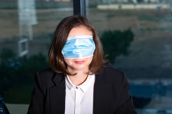 Wrong way to wear a mask against coronavirus - Beautiful Brunette Woman wearing mask to cover her eyes. Businesswoman in a mask hiding her eyes. Prevention from covid 19. Being funny and crazy