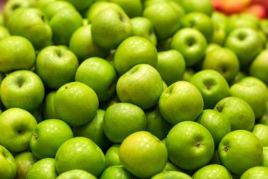 Elma meyvelerinin arka planı. Seçici odaklanma. Marketteki taze elma yığını marketteki kırmızı elmalar. Bulanık arkaplan.