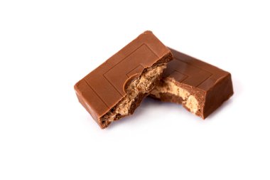 Sütlü çikolata parçaları beyaz arka planda izole edilmiş ve kırpma yolu var. Çikolatalı tatlı tatlı parçaları. Metnin için kopyalama alanı olan yan görünüm. Stüdyo çekimi