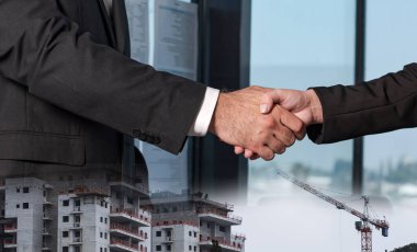 İş adamları iş anlaşması ya da mimari proje ve bağlantı için el sıkışıyorlar. Modern hayat, iş hayatı, şehir hayatı, inşaat ve ortaklık kavramı.