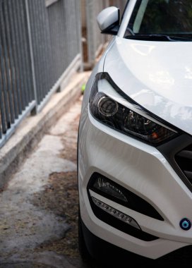 Beyaz lüks arabada temiz farlar. Ön sağ farın yakın çekimi. Metin için sol tarafta boş alan.