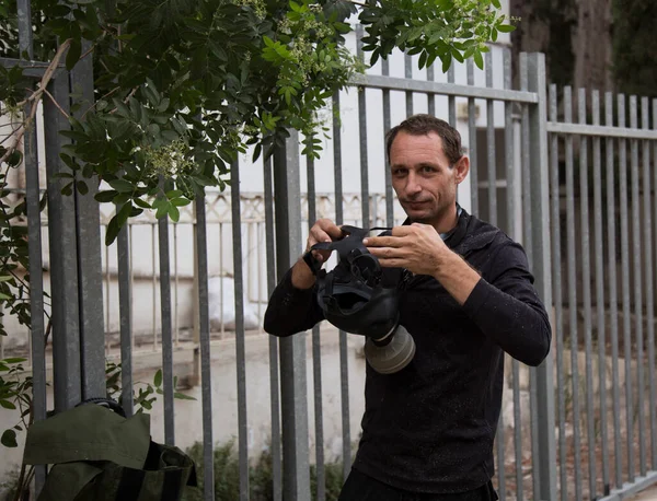 man wearing a gas mask on a city street. The man prepare to wear oxygen mask.