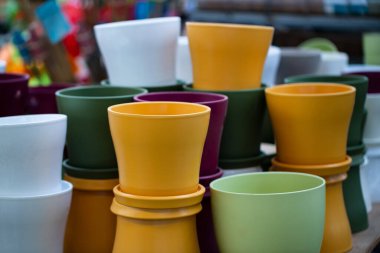 Bir bahçe mağazasında birçok renkli tencere var. Dekoratif plastik saksılar. Plastik geri dönüşümü. Bahçe işleri için plastik çatal bıçak üretimi