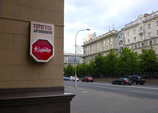 Minsk, Bielorrusia - 29 de junio de 2018: Vista de la calle del centro de Minsk, Bielorrusia. Señal de calle Cuidado con el coche — Foto de Stock