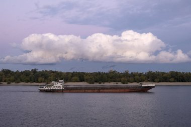 Trukhanov Adası boyunca Dinyeper Nehri'ndeki günbatımı üzerinde yüzen mavna. Kyiv, Ukrayna