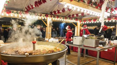 Poznan, Polonya - 04 Aralık 2018: İki saleswomen ile sıcak yemek satan bir Noel büfe içinde. Poznan içinde belgili tanımlık Noel çarşı sakinleri ve turistler ziyaret edin. Polonya