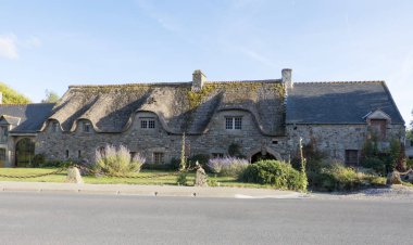 Normandy, France - August 17, 2018: Old beautiful traditional stone house with thatched roof in Brittany not far from Mont Saint Michel . Brittany Normandy France clipart