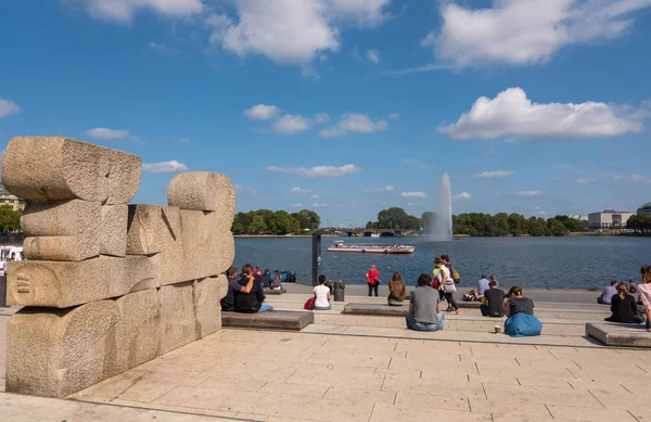 Un gruppo di persone che riposano sulla riva del lago Alster nel centro di Amburgo, Germania — Foto Stock