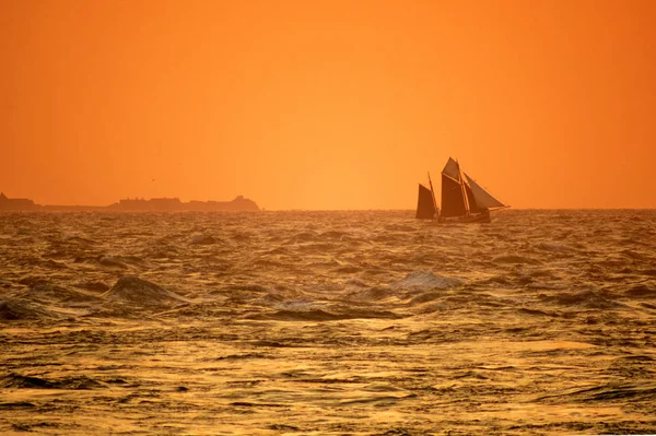 Gün batımında deniz manzarası. Cap de la Hague yakınlarında gün batımında yelkenli tekne, — Stok fotoğraf