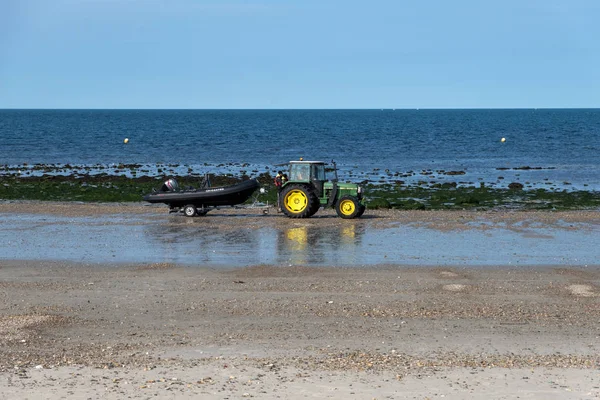 O trator carrega o barco na praia em Cherbourg. Normandia, França — Fotografia de Stock