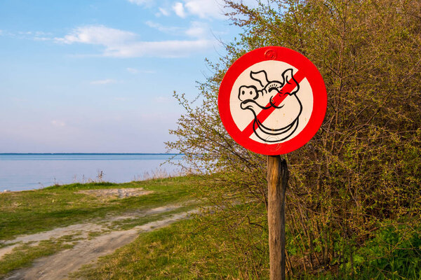 A sign depicting a pig, calling not to litter in the woods. Kiev region, Ukraine