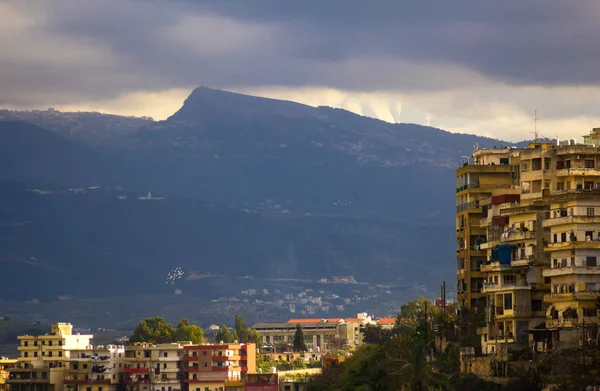 Pohled na město a hory pod chmurným nebem. Tripolis, Libanon — Stock fotografie