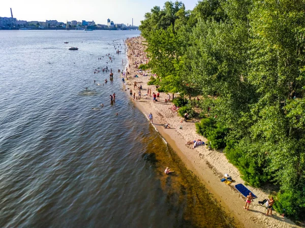 La gente descansa en las orillas del río Dnipro en el área de recreación de la isla de Trukhaniv, Kiev, Ucrania — Foto de Stock