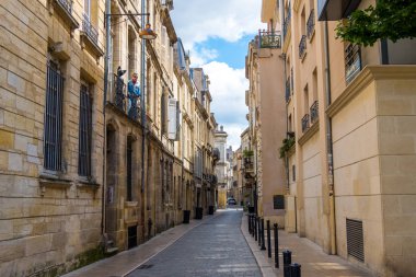 Siyah bir kedi ve Bordeaux, Fransa tarihi merkezinde eski bir evin balkonunda bir adam manken