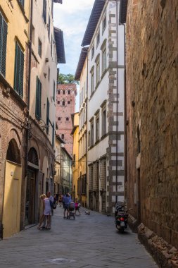 Lucca, İtalya - 14 Ağustos 2019: Eski dar ortaçağ caddesinde Lucca, Toskana 'nın tarihi merkezinde kafe ve dükkanları olan turistler ve yerel halk