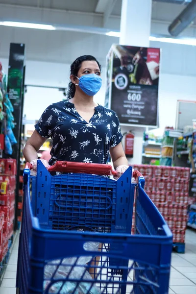 10 Haziran 2020. Madrid Spaid. Beyaz kadın kendini virüslerden korumak için hijyen kurallarına uyan mavi elbiseli bir süpermarkette alışveriş yapıyor..