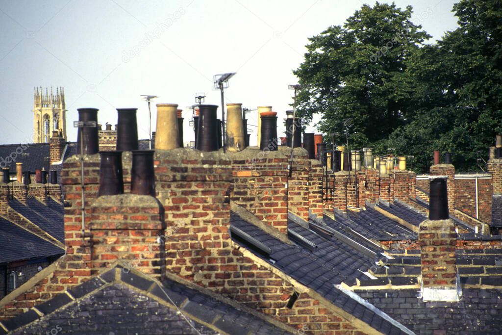 Old Victorian terraced house chimney stacks and chimney pots in lines in the City of York, UK