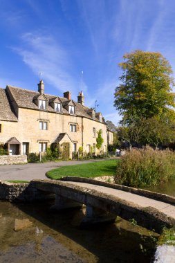 Aşağı Katliam, Gloucestershire, İngiltere 'nin nehir kenarındaki sakin Cotswold kulübelerinde sonbahar güneşi.