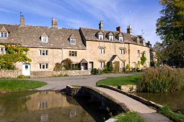 Aşağı Katliam, Gloucestershire, İngiltere 'nin nehir kenarındaki sakin Cotswold kulübelerinde sonbahar güneşi.