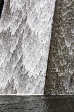 Llys y Fran Rezervuar Barajı, Pembrokeshire, Galler, İngiltere 'nin batık beton duvarına beyaz su taştı.