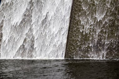 Llys y Fran Rezervuar Barajı, Pembrokeshire, Galler, İngiltere 'nin batık beton duvarına beyaz su taştı.