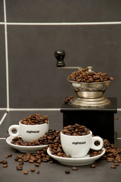 烤咖啡豆 浓缩咖啡杯和磨床在铺好瓷砖的厨房工作表面上的静止不动的生活 — 图库照片