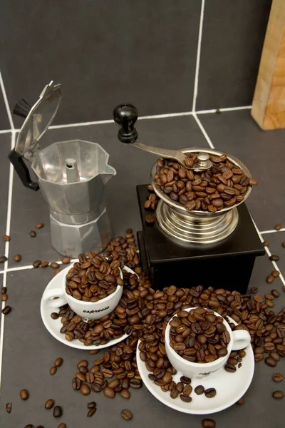 烤咖啡豆 浓缩咖啡杯和磨床在铺好瓷砖的厨房工作表面上的静止不动的生活 — 图库照片