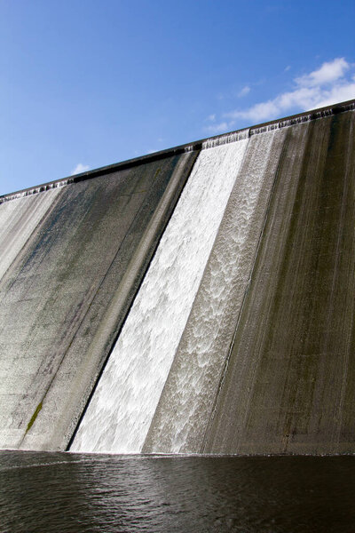 White water overspill run off on the stark sunlit concrete wall of Llys y Fran Reservoir Dam, Pembrokeshire, Wales, UK