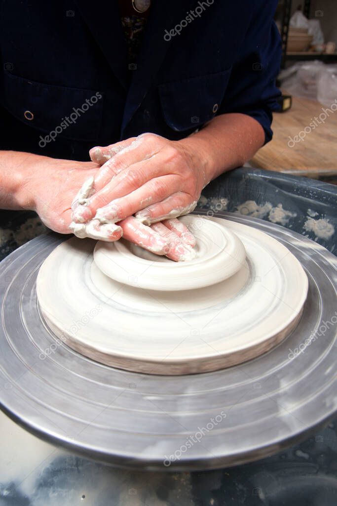 A lady ceramics artist at work in her home pottery studio, opening up