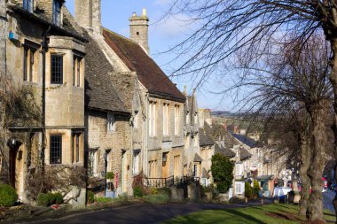 Burford, Oxfordshire, İngiltere - 3 Şubat 2011: The Cotswolds, İngiltere 'de Burford' un ana caddesi olan The Hill 'i oluşturan pitoresk evlerde kış güneşi. Burford, 