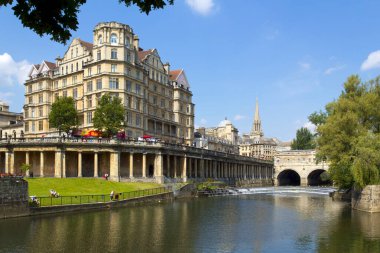 Bath, İngiltere - 3 Temmuz 2011: İngiltere 'nin Somerset kentindeki Bath şehrinde yaz güneşinde Avon Nehri yakınlarındaki gezginler. Bath, UNESCO 'nun dünya mirası sitesidir. Mimarisi ile ünlüdür..