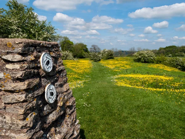 Haresfield, Gloucestershire, İngiltere - 15 Mayıs 2014: Cotswold Yolu, Gloucestershire, İngiltere 'deki Haresfield Beacon' da eski bir trigonometri noktasında uzun mesafe patikası.