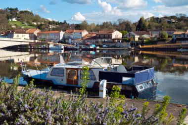 28 Mart 2017 - Saint-Sylvestre-sur-Lot, Fransa: Saint- Sylvestre-sur-Lot, Lot-et-Garonne, Fransa 'da bahar sabahı güneşinde demirlemiş tekneler. Nehrin karşısında Penne Limanı, Penne d 'Agenais' in antik nehir limanı...