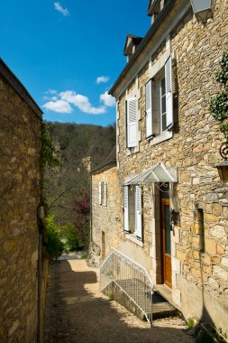 La Roque-Gageac, Fransa - 3 Nisan 2017: Dordogne, Nouvelle Aquitaine, Fransa 'daki Dordogne Nehri kıyısındaki kayalıkların altındaki La Roque-Gageac' ta resim mimarisi. Les Plus Beaux Villages de France 'ın bir üyesidir..