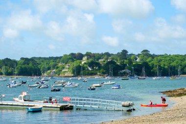 Helford Passage, İngiltere - 8 Haziran 2017: İki kişi İngiltere 'nin Cornwall kentindeki Helford Passage kırsalından kanoya binmeye hazırlanıyor. Helford Nehri (sel basmış nehir vadisi) Cornwall AONB 'de (Outstandi Bölgesi) turizm merkezi olarak bilinen bir nehirdir.