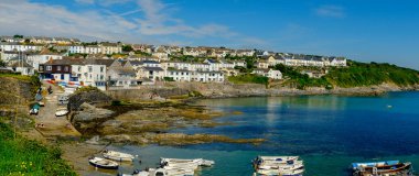 Portscatho, Cornwall, İngiltere - 25 Temmuz 2017: Tatilciler güzel bir yaz sabahı İngiltere 'nin Cornwall kentindeki Portscatho sahilinin canlı mavi sularının tadını çıkarıyorlar. Portscatho Roseland Peninsul 'da popüler bir aile deniz kıyısında tatil yeri.