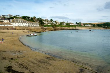 26 Temmuz 2017 - St Mawes, Cornwall: Ziyaretçiler, İngiltere 'nin Cornwall kentindeki Roseland Yarımadası' ndaki St. Mawes 'da bir yaz öğleden sonrasında dalgaların altında plajın keyfini çıkarıyorlar.