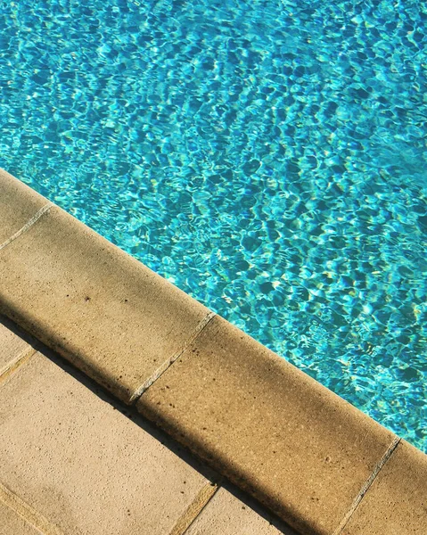 游泳池边的石雕细部阳光表面荡漾着涟漪 带有某些移动设备后处理效果的手机照片 — 图库照片