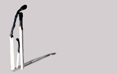 Gri arkaplanda kibrit yakmak. 