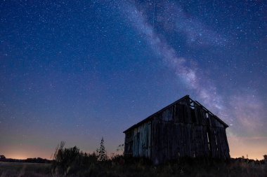 Gece gökyüzünde samanyolu terk edilmiş ahırın üstünde