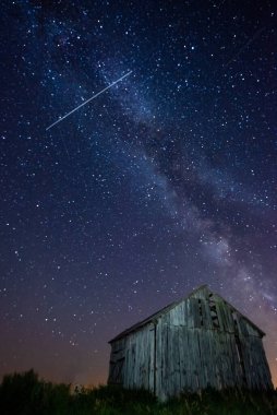 Gece gökyüzünde samanyolu terk edilmiş ahırın üstünde