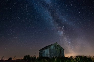 Gece gökyüzünde samanyolu terk edilmiş ahırın üstünde