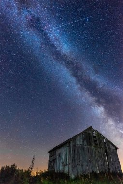 Gece gökyüzünde samanyolu terk edilmiş ahırın üstünde