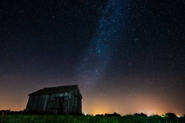 Gece gökyüzünde samanyolu terk edilmiş ahırın üstünde